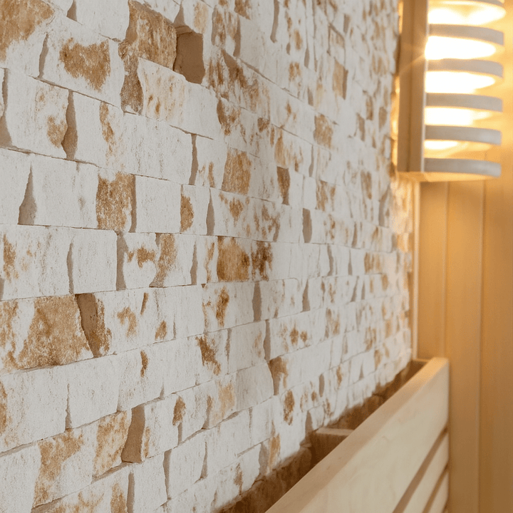 Interior view of a luxury two-person sauna featuring natural stone walls and soft lighting