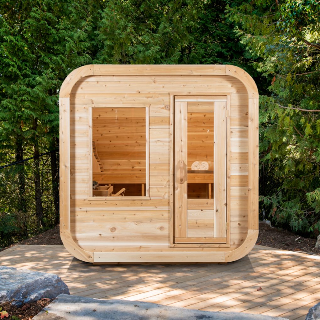 Leisurecraft outdoor luxury sauna made of natural wood with glass door and window in a forest setting