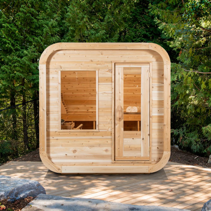 Leisurecraft outdoor luxury sauna made of natural wood with glass door and window in a forest setting