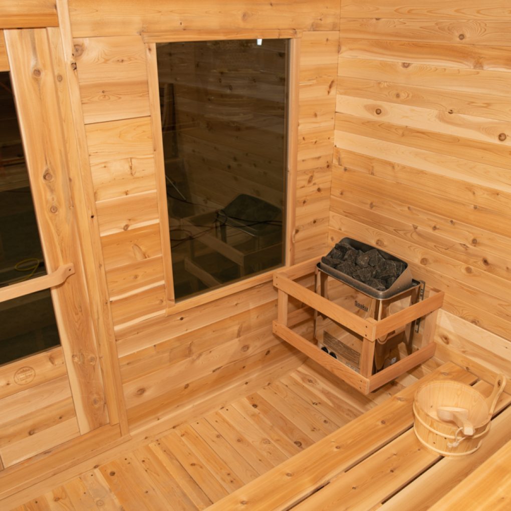 Leisurecraft traditional outdoor luxury sauna interior with wooden benches and heater with sauna stones