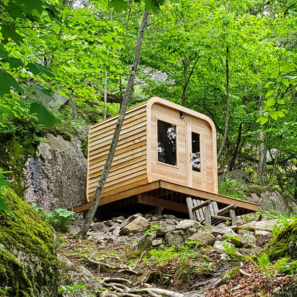 Leisurecraft traditional outdoor luxury sauna made of wood set in a forest on a raised platform