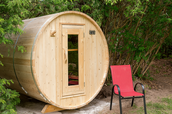 Leisurecraft wooden barrel sauna outdoors with red chair next to the home spa sauna kit