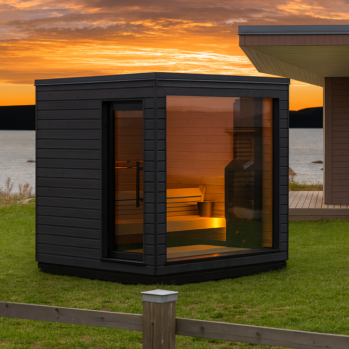 SaunaLife modern black cube with glass front showing bench and heater by lake at sunset outdoor pre-assembled sauna