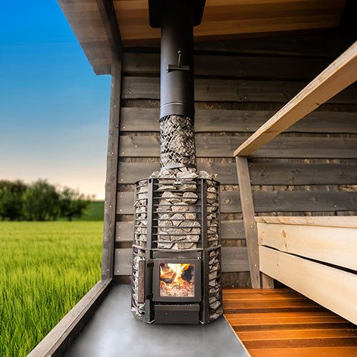Narvi Inari sauna stove with heated stones inside a wooden sauna room overlooking green field