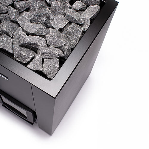 Close up of Narvi Kaamos 20 wood sauna stove black metal corner with stacked sauna stones and firebox door