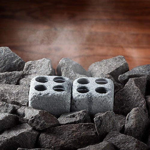Hukka Finnish soapstone steam stones two four hole cube sauna stones on hot sauna rocks with rising steam