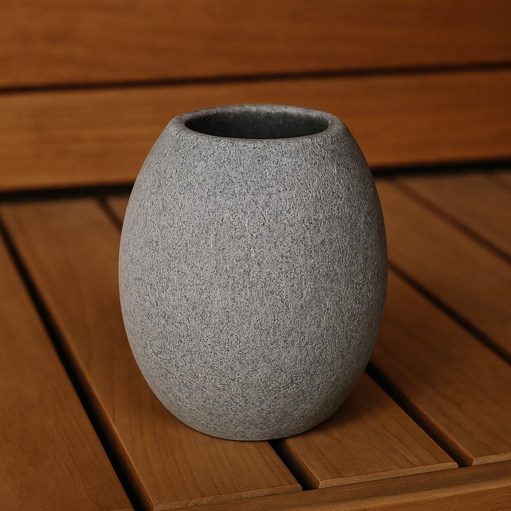 Hukka soapstone sauna cup rounded gray stone cup on wooden sauna bench textured surface