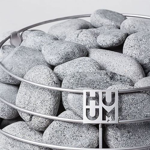 HUUM accessory with olivine diabase sauna stones in a metal holder for sauna heating