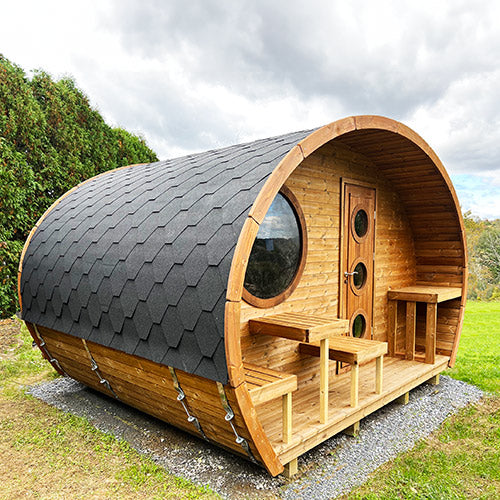 SaunaLife traditional outdoor home sauna kit with barrel design and wooden benches on grassy lawn