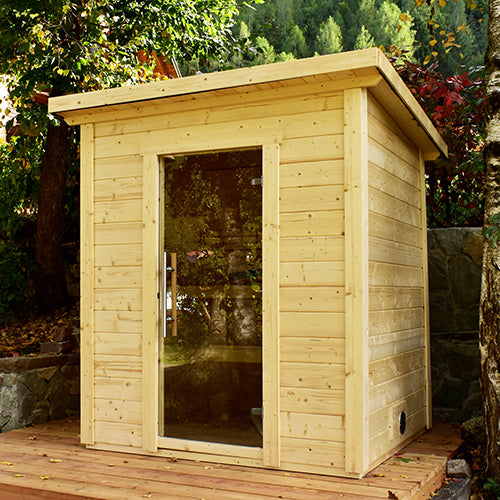 SaunaLife traditional wooden outdoor home sauna kit with glass door on wooden deck in forest setting