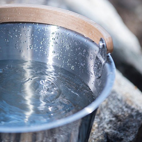 Rento Harri Koskinen sauna bucket featuring a sleek stainless steel design and a wooden handle