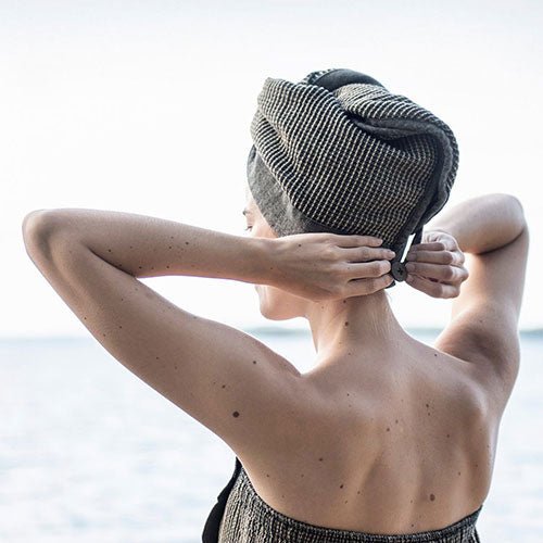 Woman using Rento Kenno hair towel for quick drying after a shower with stylish design