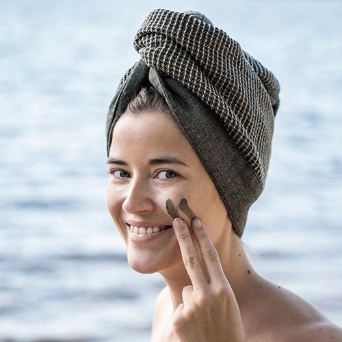 Rento Kenno hair towel wrapped stylishly as the model applies facial clay by the water