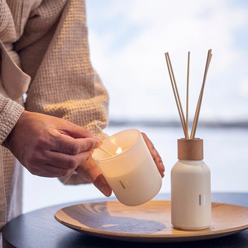 Rento luxury soy scented candle being lit in a cozy setting for a relaxing ambiance