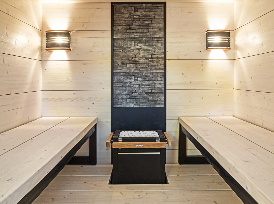 Harvia sauna heater with white decorative sauna stones in a modern wooden sauna interior