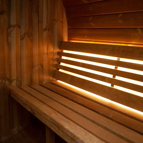 Interior wooden bench seating with ambient lighting inside SaunaLife E8W sauna barrel review