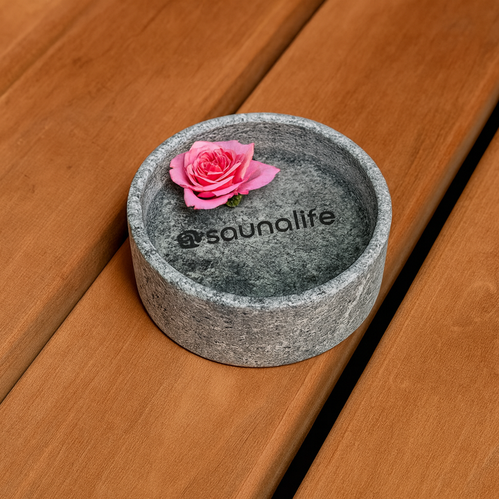 SaunaLife sauna aroma cup made of gray stone with a pink rose on a wooden sauna bench