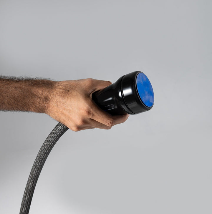 Hand holding Vacuactivus ICEBERG Cryonick Roller with a flexible hose for wellness and recovery treatments