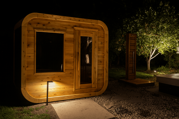 Leisurecraft outdoor luxury sauna made of natural wood, showcasing a modern design in a nighttime garden setting